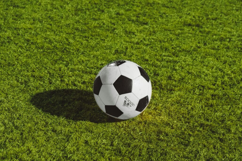 Bal&oacute;n de f&uacute;tbol blanco y negro sobre el c&eacute;sped.