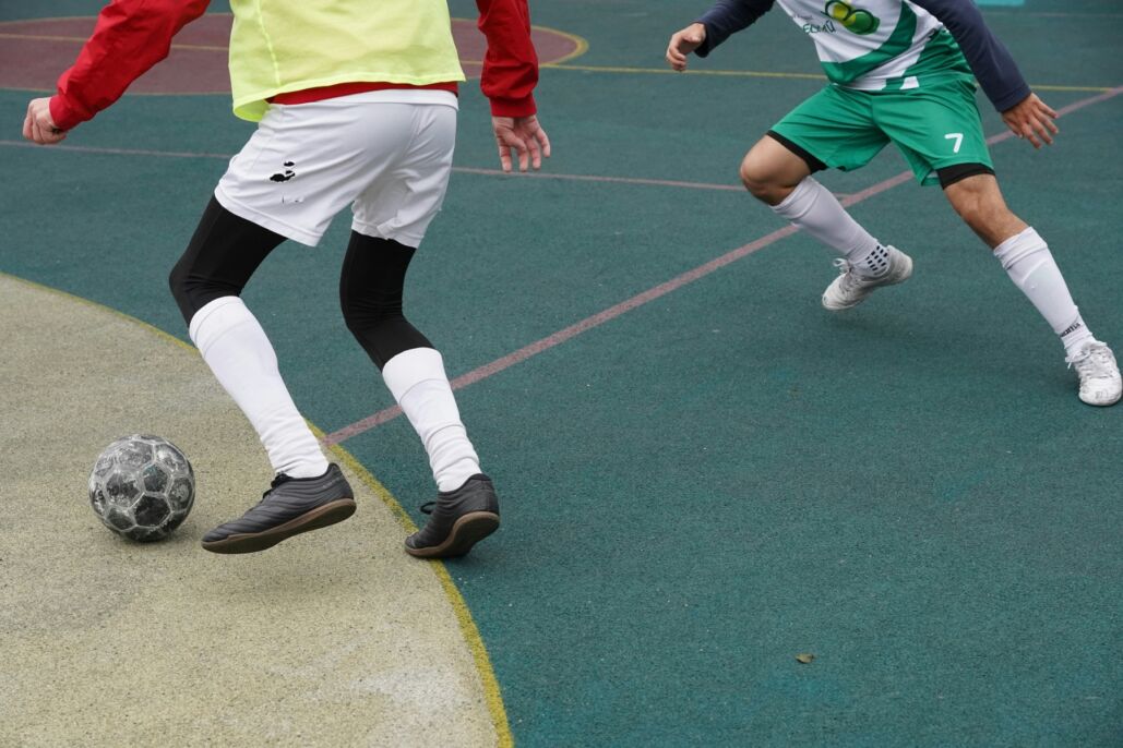 Dos jugadores disputan el bal&oacute;n en una cancha de superficie dura.