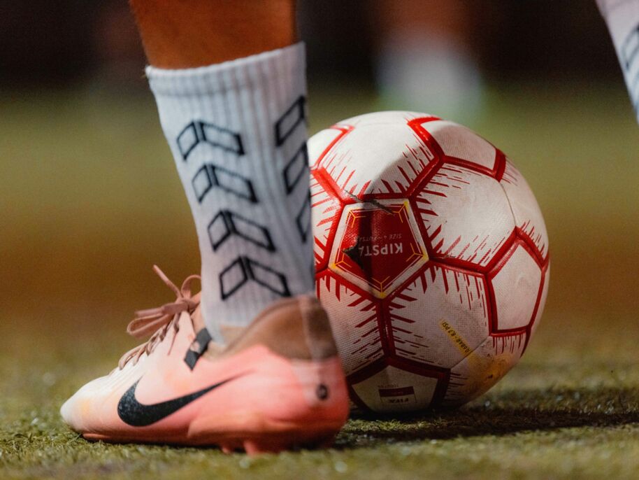 Pie de un jugador junto al bal&oacute;n sobre el c&eacute;sped.