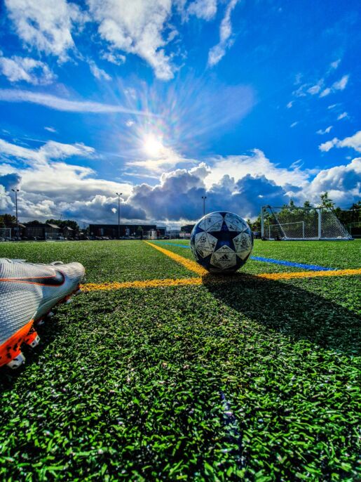 Bal&oacute;n blanco y azul sobre una cancha de c&eacute;sped bajo un cielo nublado.