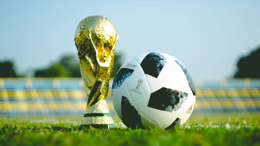 Trofeo dorado junto a un balón de fútbol.